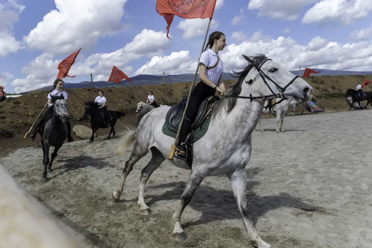 Un călăreț pe un cal alb întoarce în fruntea procesiunii.