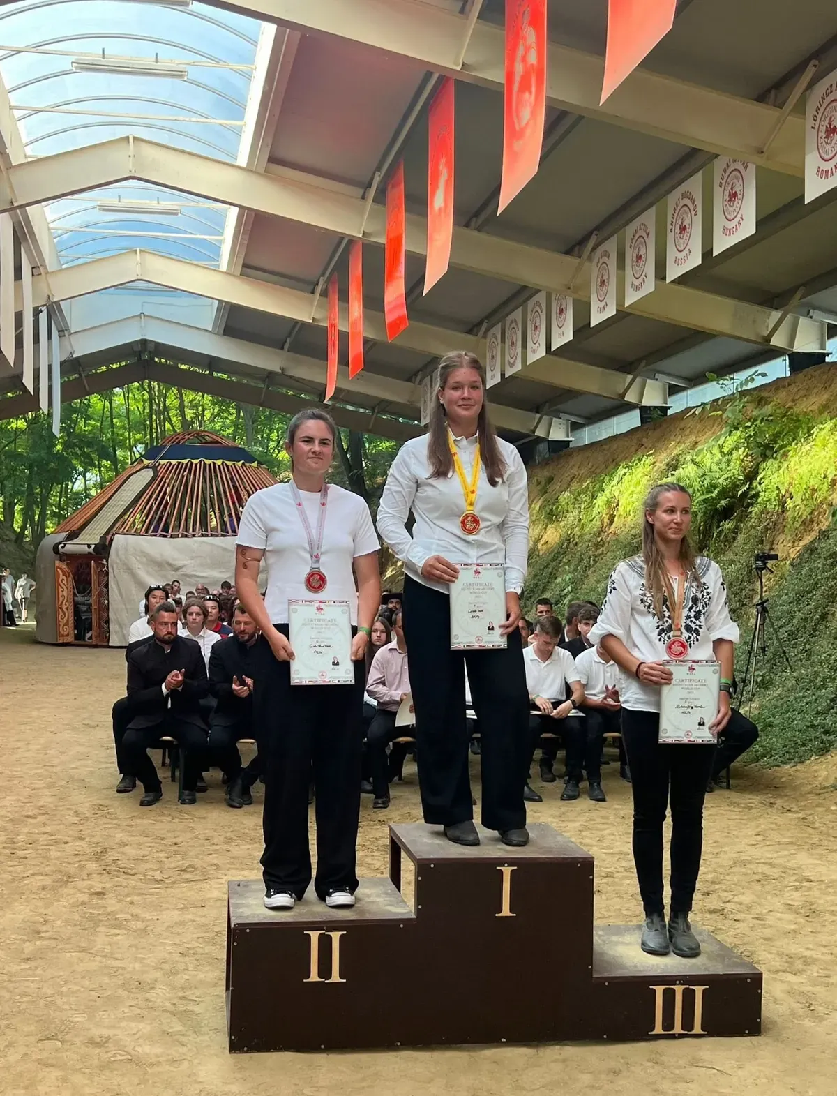 Csiszér Ivett stă pe prima treaptă a podiumului, cu medalia și diploma în mână.